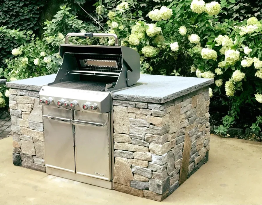 Stone-clad outdoor kitchen with built-in grill
